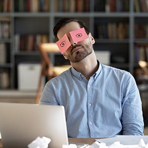 A sleeping worker with pink paper covering his eyes - Leep Tescher Helfman and Zanze
