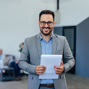 Smiling professional man with clipboard in office - Leep Tescher Helfman and Zanze