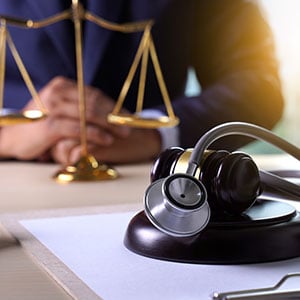 Stethoscope placed on a lawyer's desk, representing law and healthcare - Leep Tescher Helfman and Zanze