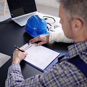A person filling out a workers’ compensation claim form - Leep Tescher Helfman and Zanze
